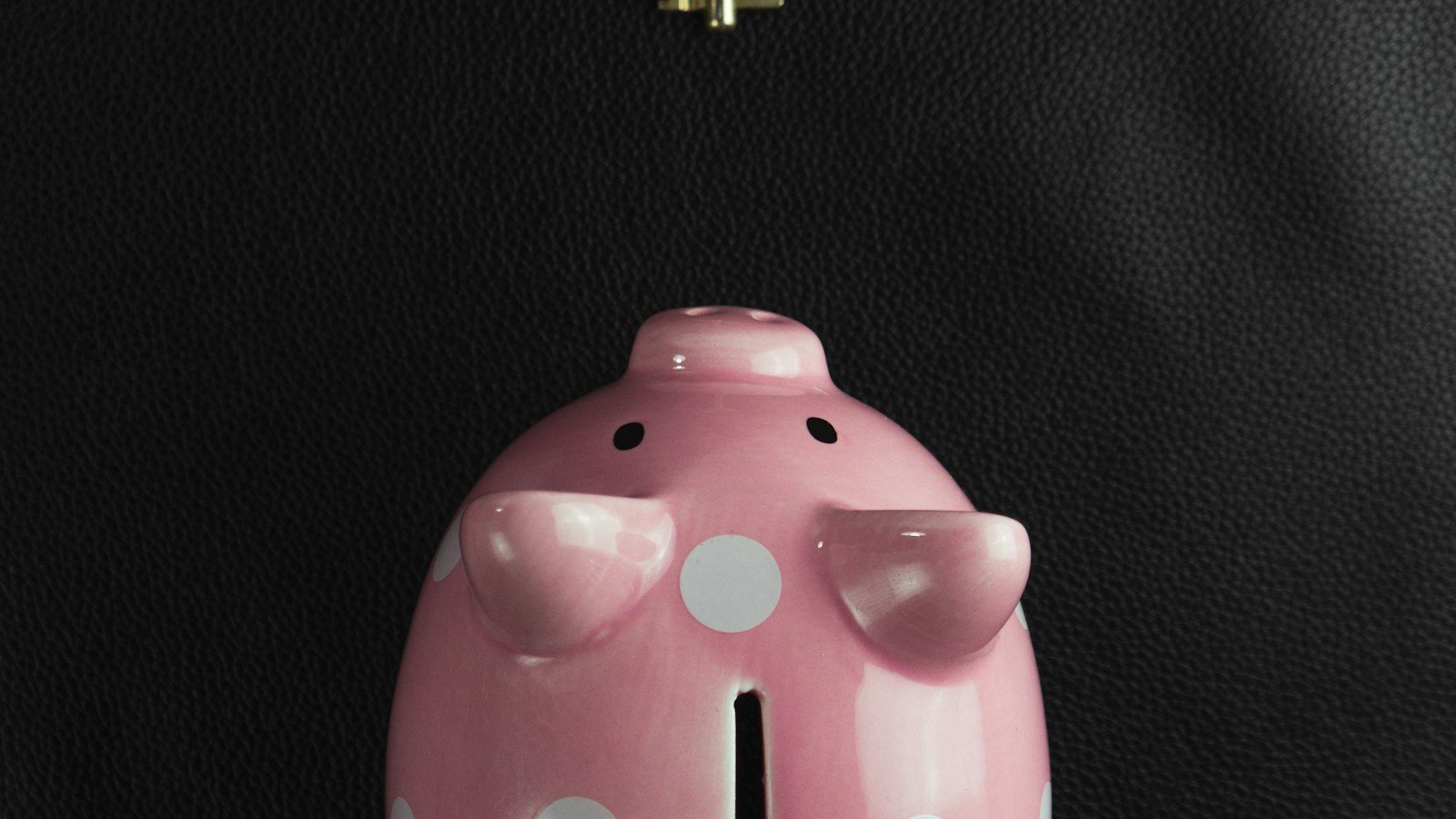 Pink piggy bank with a key hanging from it