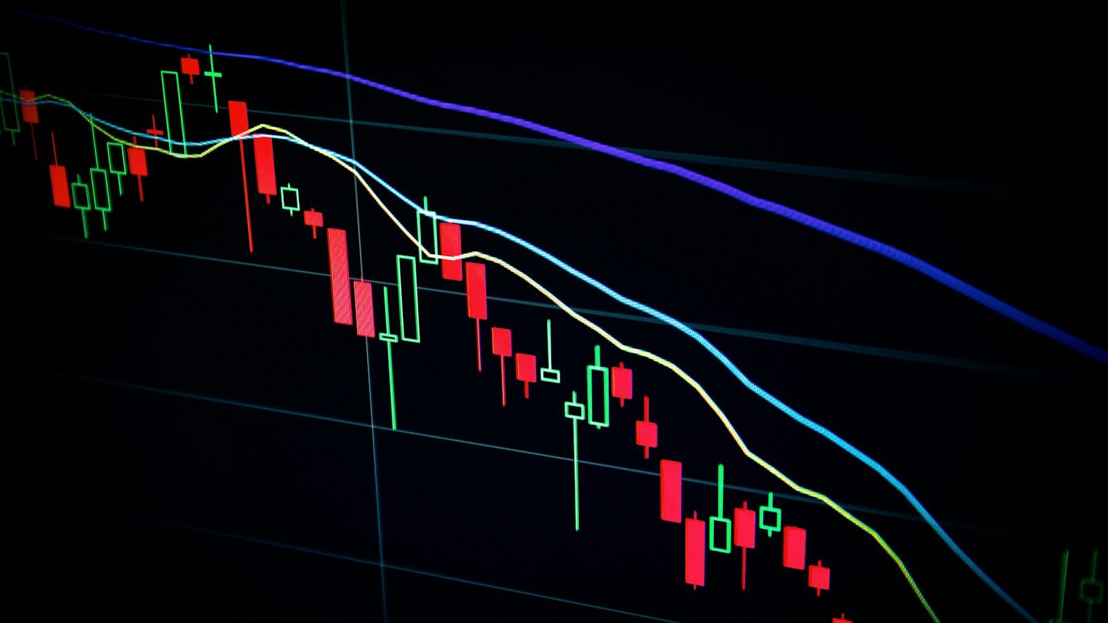 Stock market candlestick chart on a dark screen