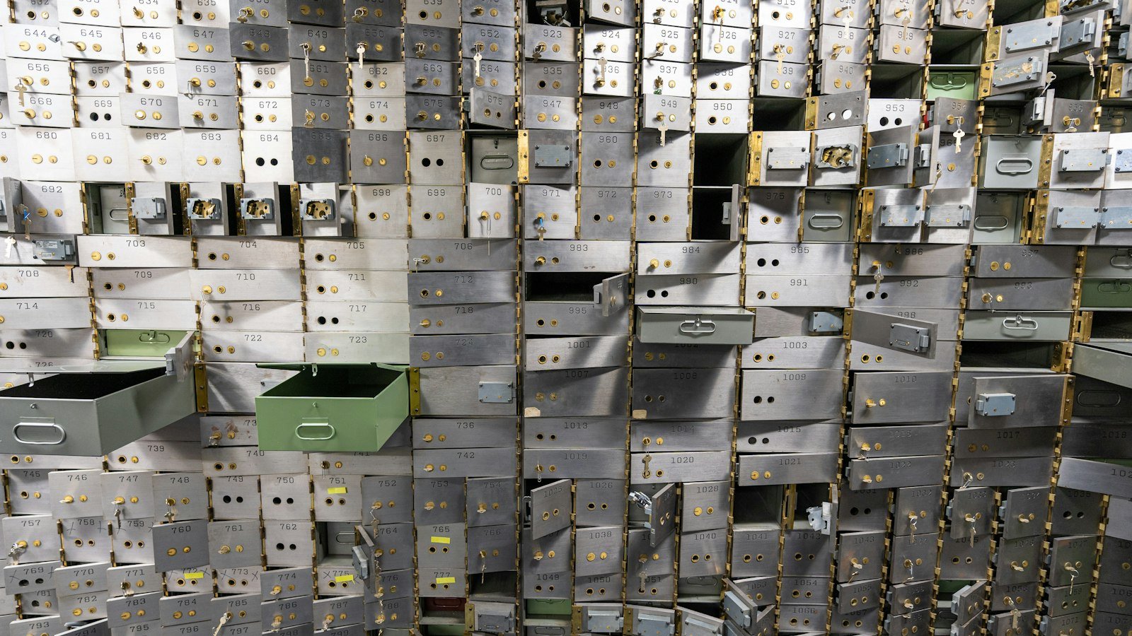 Rows of metal safe deposit boxes inside a bank vault
