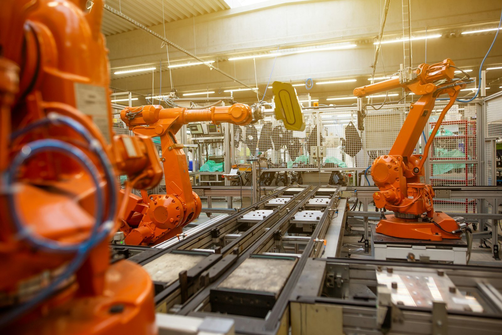 A factory filled with orange automated machines, illustrating manufacturing activity tracked by the PMI